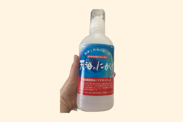 天海のにがり液体を手に持っている